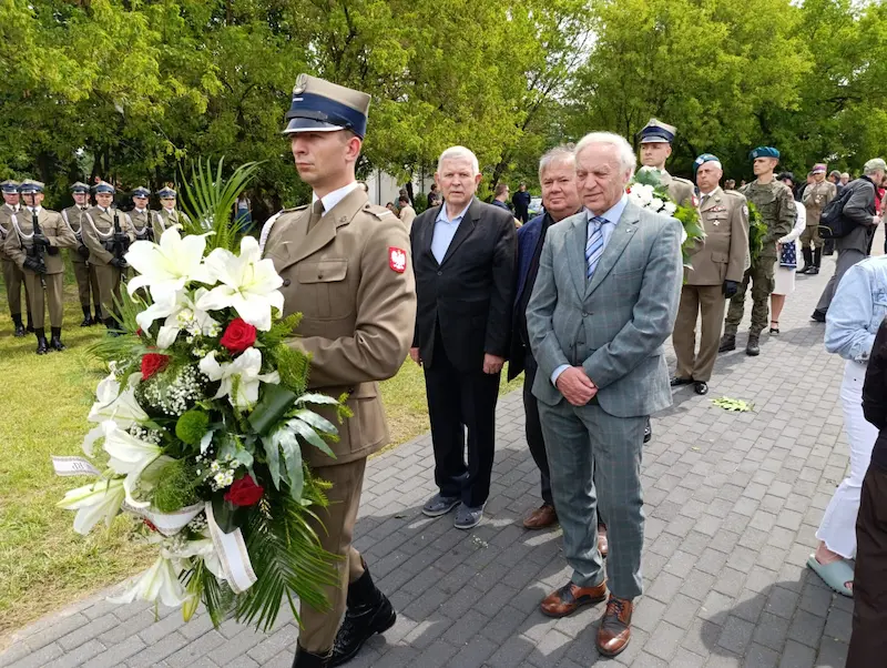Delegacja z wiązanką kwiatów podczas uroczystości